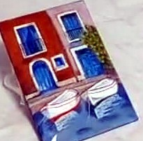 Esmalte: fachadas rojas y azules con dos barcas amarradas