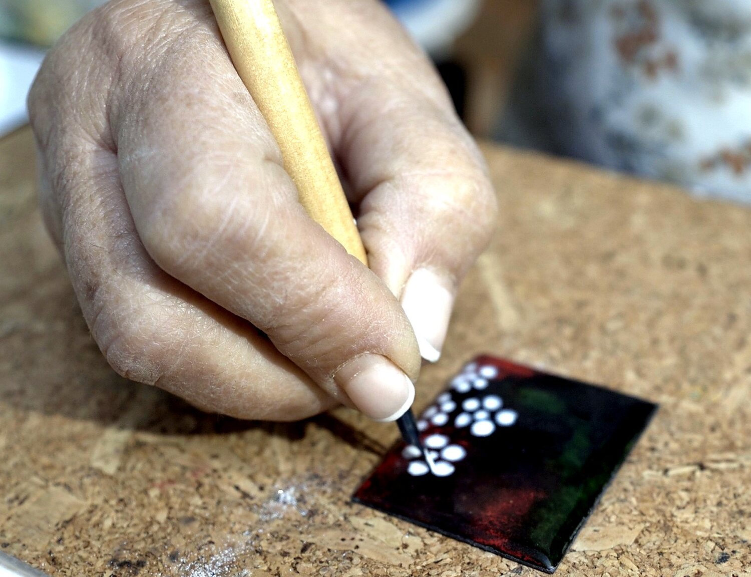 Detalle de una mano pintando con polvo de vidrio