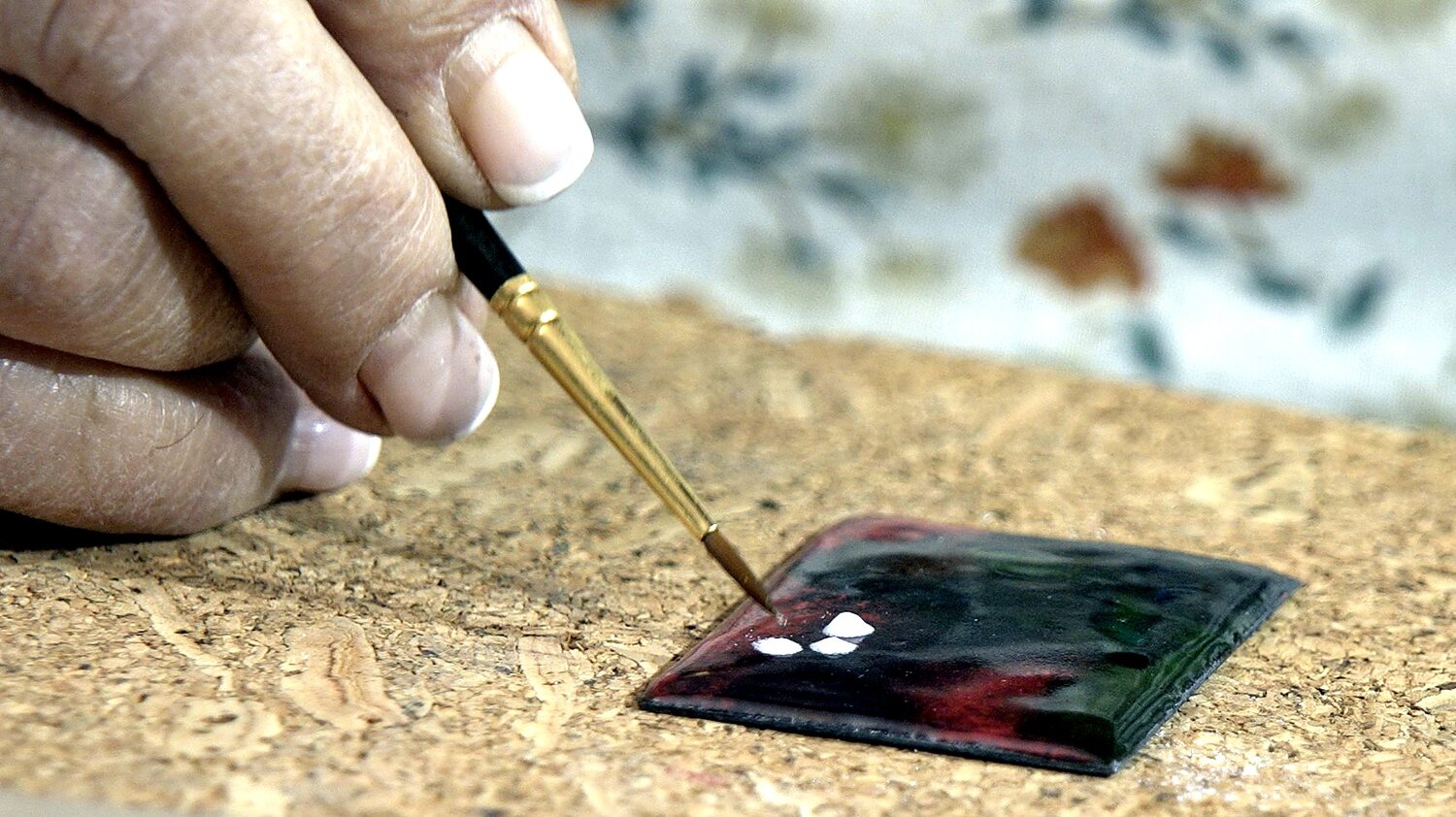 Pincel trabajando sobre un esmalte verde